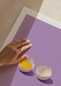 A golden egg in cracked shell against a purple background with a playful, stylish feel.-9