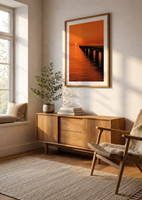 A lone person on a pier in a glowing orange sunset light.-8