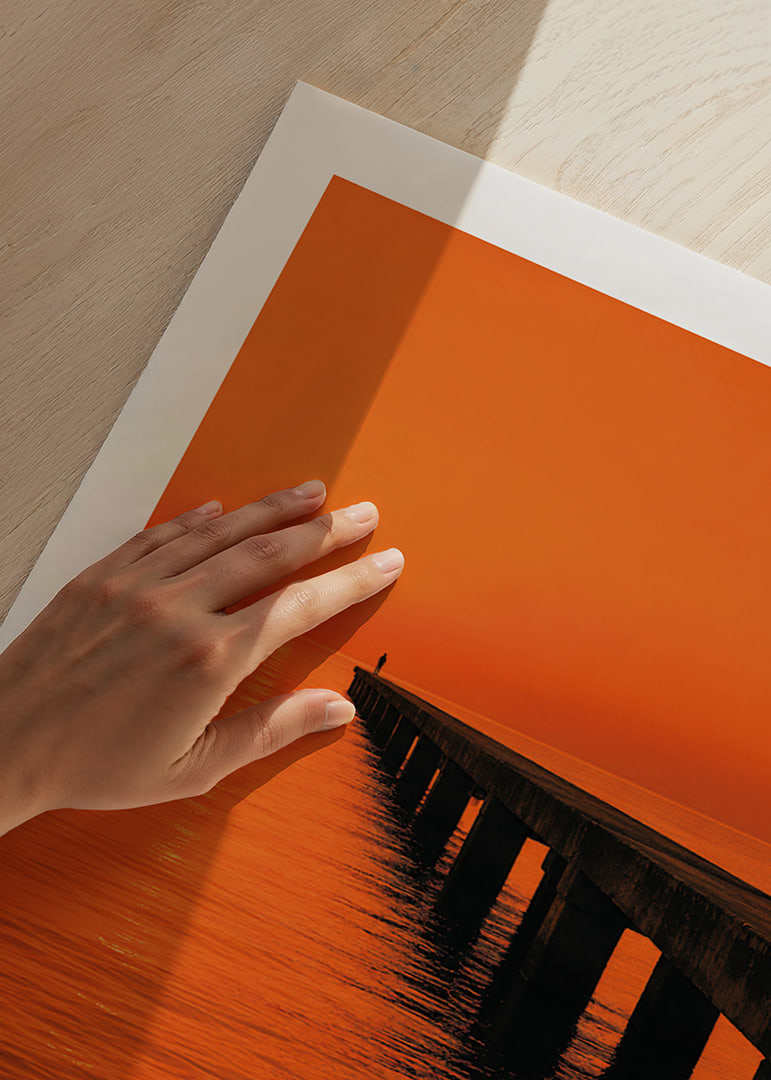 A lone person on a pier in a glowing orange sunset light.-12