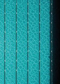Turquoise pool water and dark track lines create a cool, graphic rhythm.-7