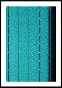 Turquoise pool water and dark track lines create a cool, graphic rhythm.-0