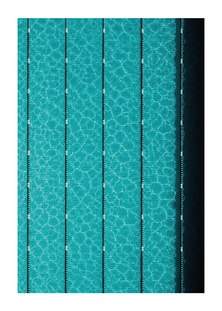 Turquoise pool water and dark track lines create a cool, graphic rhythm.-12