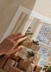 Los regalos de Navidad bellamente envueltos junto a una ventana soleada crean un ambiente cálido y acogedor en invierno.-9