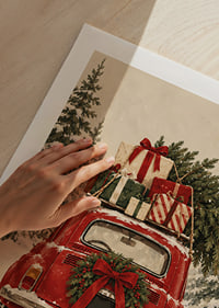 Un coche antiguo rojo, cargado de regalos de Navidad, atraviesa un bosque de abetos nevado.-9