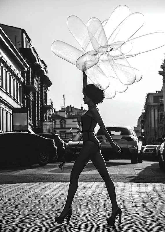 Black and white silhouette of woman with balloons in urban environment-12