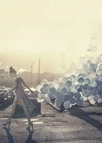 Photograph of woman in gray dress with blue balloons on street-7