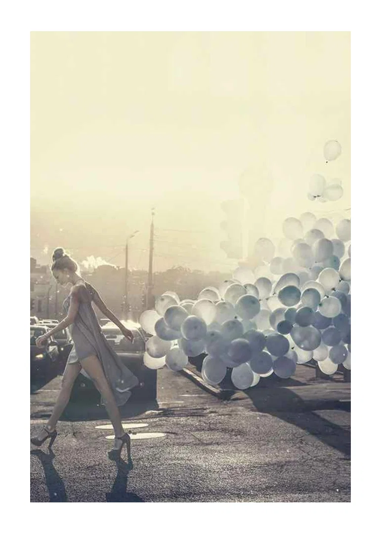 Photograph of woman in gray dress with blue balloons on street-12