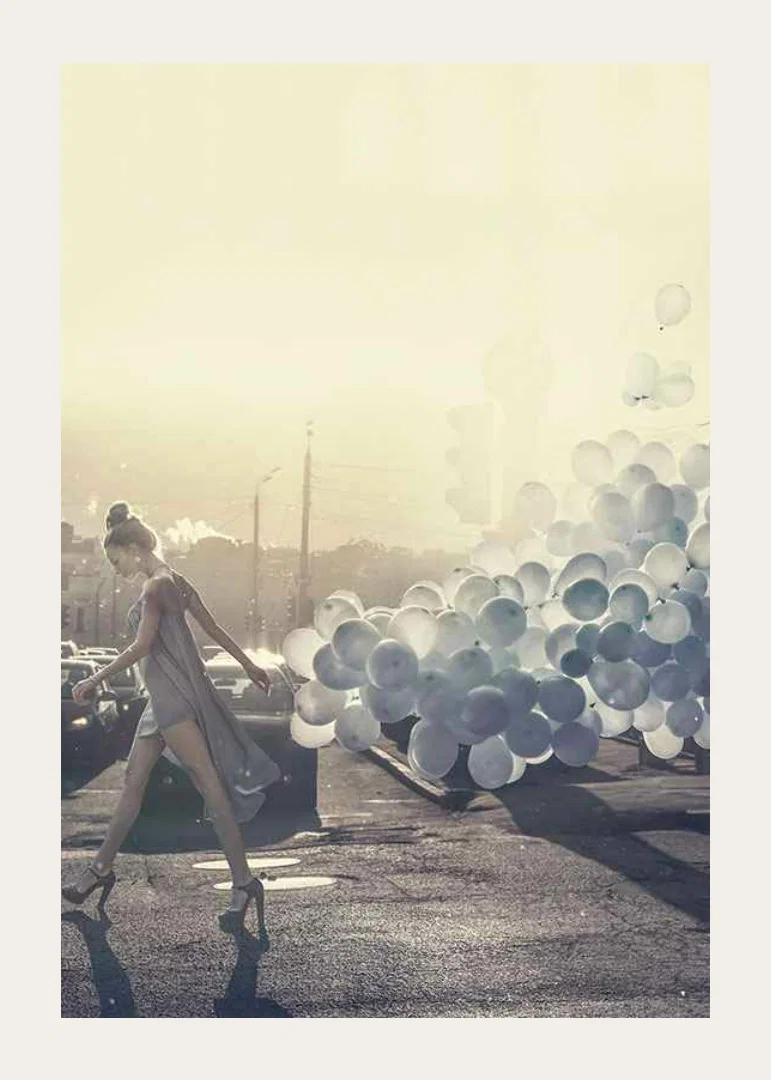 Photograph of woman in gray dress with blue balloons on street-12