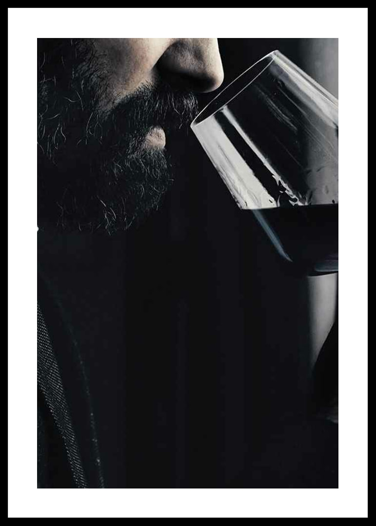 Close-up of man with beard smelling red wine in glass-12