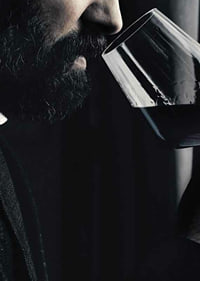 Close-up of man with beard smelling red wine in glass-7