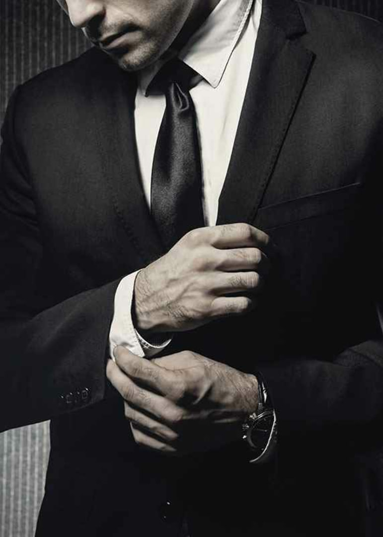 Close-up of man in black suit adjusting cufflinks-12