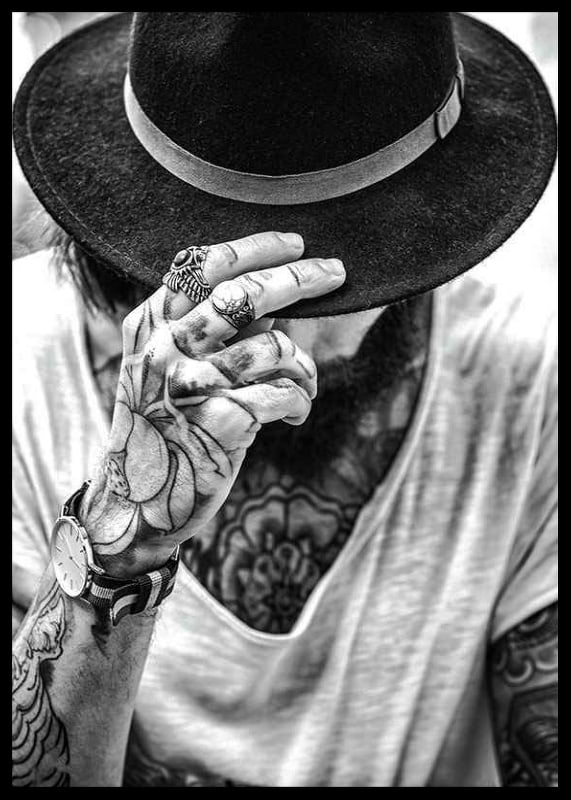 Black and white close-up of tattooed man with hat and jewelry-12