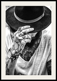 Black and white close-up of tattooed man with hat and jewelry-2
