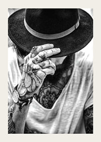 Black and white close-up of tattooed man with hat and jewelry-3