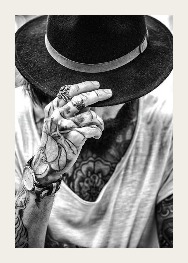 Black and white close-up of tattooed man with hat and jewelry-12