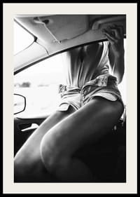 Black and white photo of woman in shorts, sitting in car window-2
