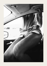 Black and white photo of woman in shorts, sitting in car window-3
