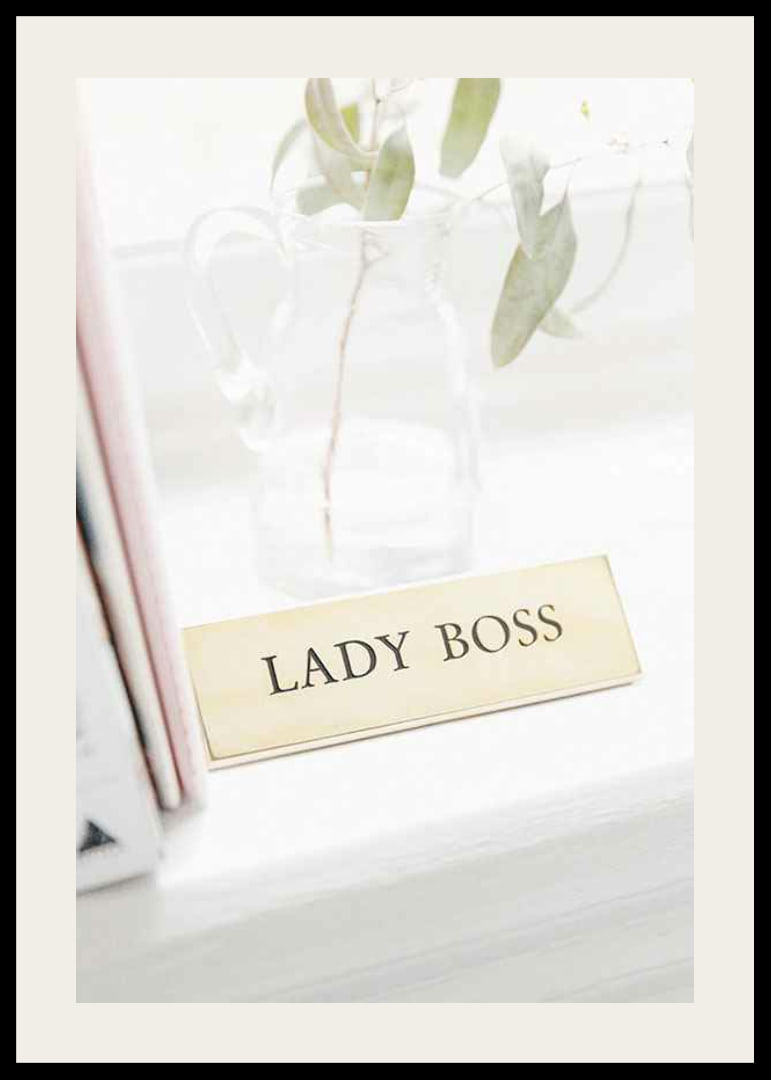Fotografi av guldfärgad skylt med texten LADY BOSS-12