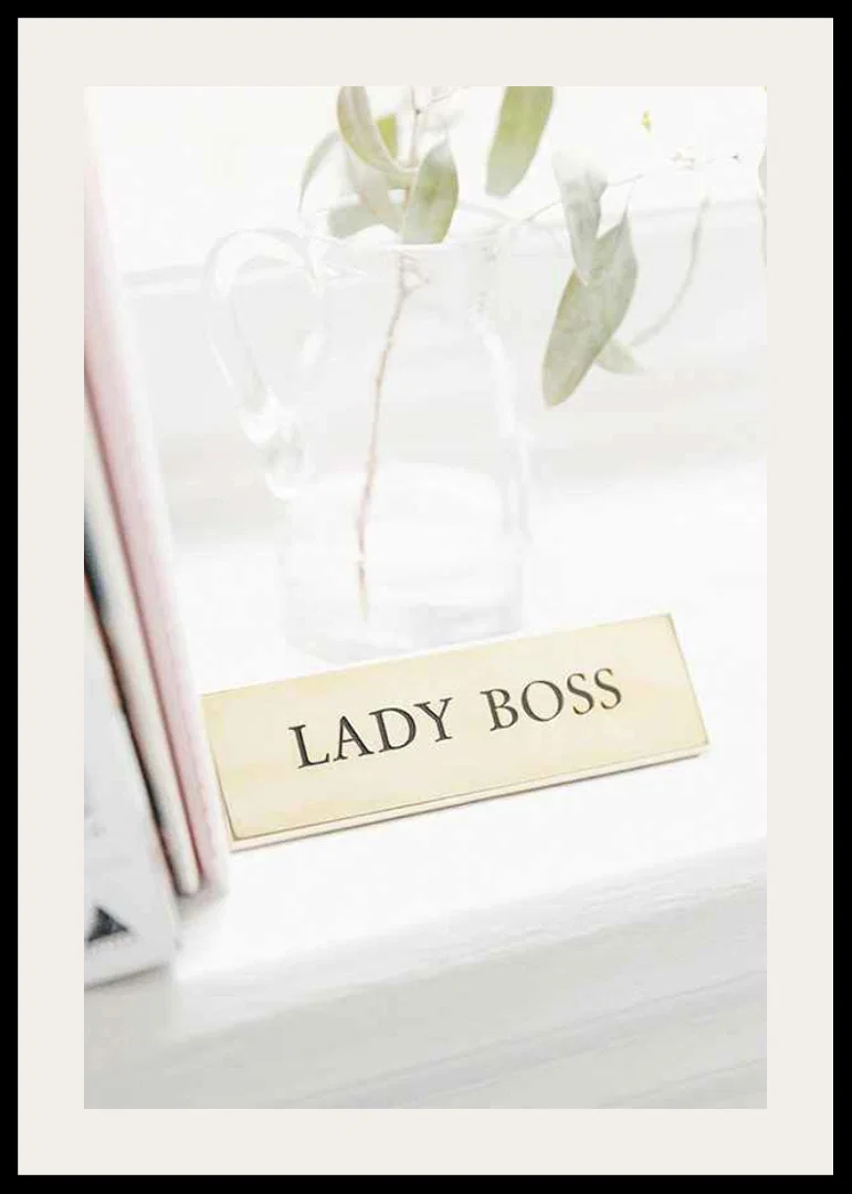 Photograph of gold-colored sign with the text LADY BOSS-12