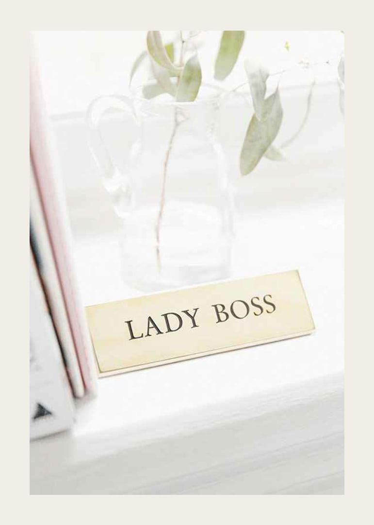 Fotografi av guldfärgad skylt med texten LADY BOSS-12