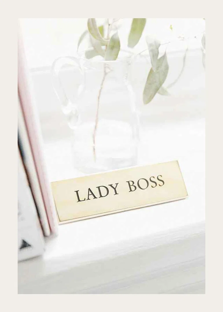 Photograph of gold-colored sign with the text LADY BOSS-12