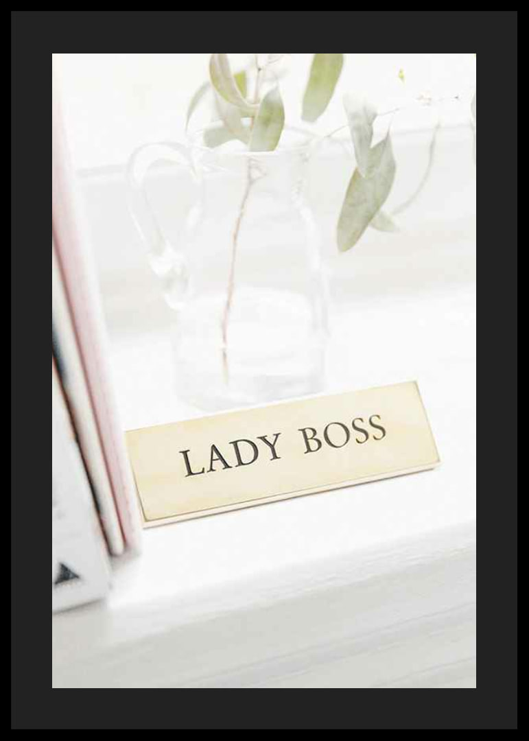 Fotografi av guldfärgad skylt med texten LADY BOSS-12