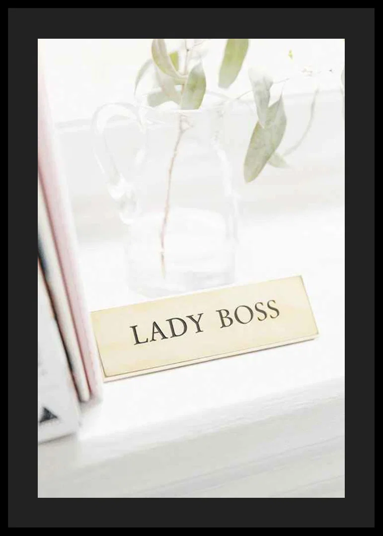 Photograph of gold-colored sign with the text LADY BOSS-12