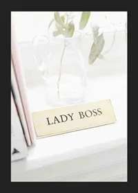 Photograph of gold-colored sign with the text LADY BOSS-5