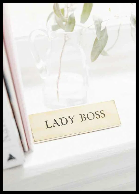 Photograph of gold-colored sign with the text LADY BOSS-12