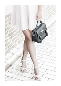 Photograph of woman in pink dress with black handbag-1