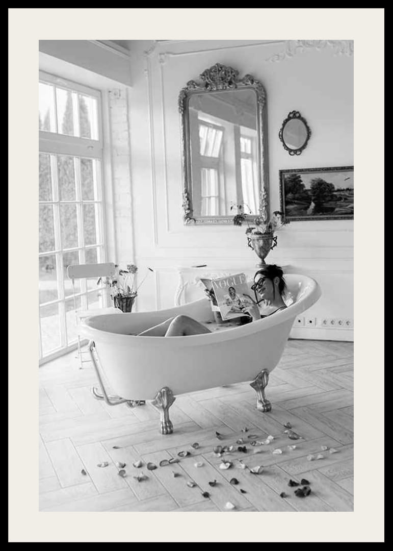 Svartvitt fotografi av kvinna i badkar som läser tidning-12