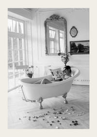 Svartvitt fotografi av kvinna i badkar som läser tidning-3