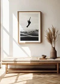 Black and white photograph of skateboarder in the air over skatepark-8