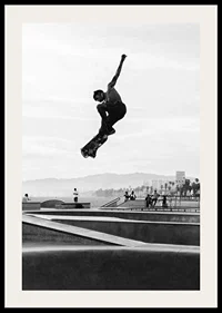Black and white photograph of skateboarder in the air over skatepark-2
