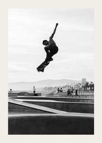 Mustavalkoinen valokuva skeittaajasta ilmassa skeittipuiston yllä-3