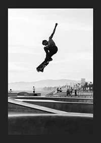 Black and white photograph of skateboarder in the air over skatepark-5
