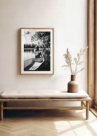 Svartvit fotografi av kvinna i båt på stilla sjö med träd-8