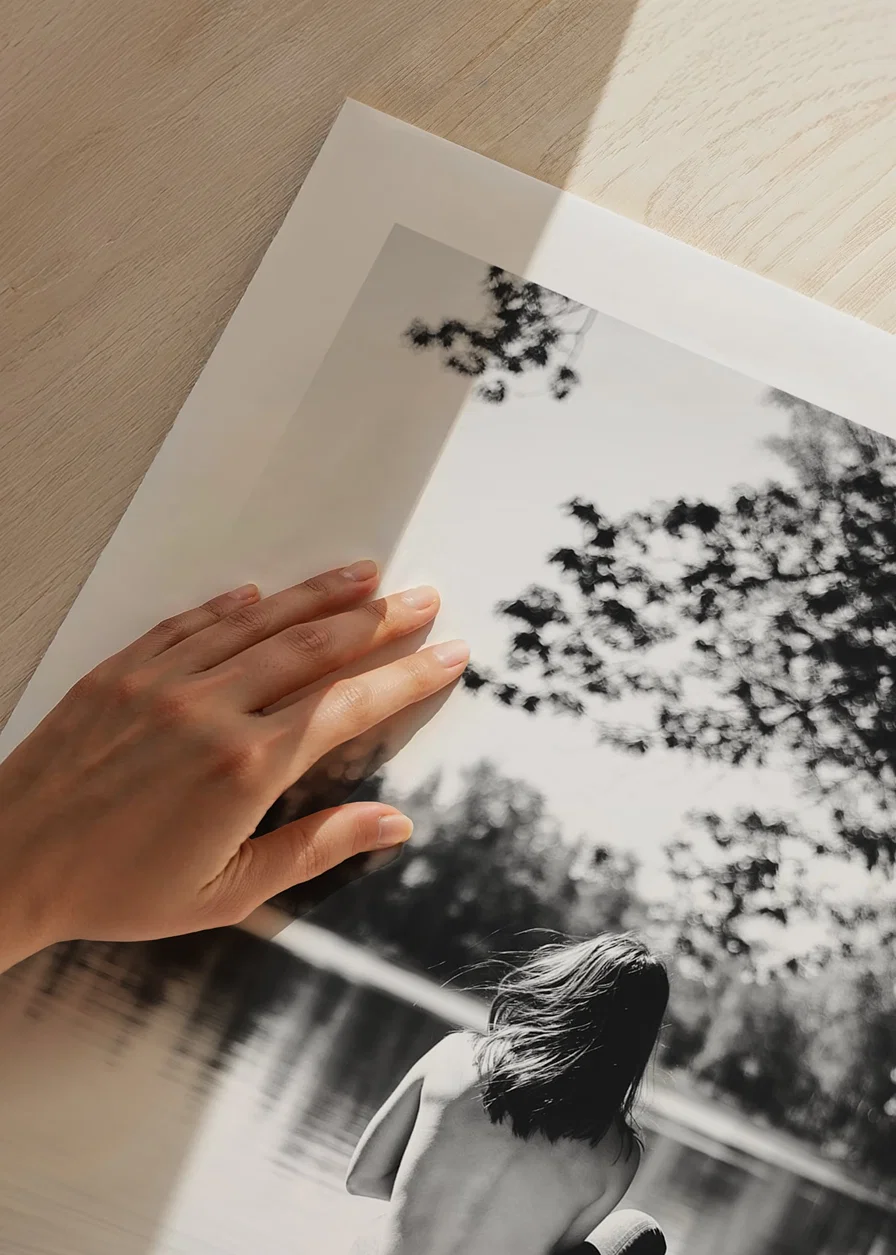 Black and white photograph of woman in boat on calm lake with trees-12