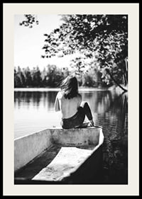 Svartvit fotografi av kvinna i båt på stilla sjö med träd-2
