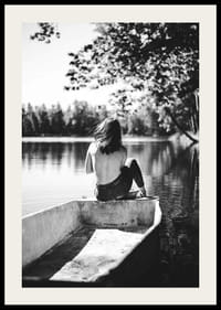 Fotografía en blanco y negro de una mujer en un bote en un lago tranquilo con árboles.-2