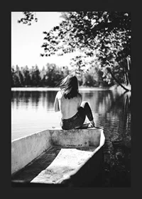 Black and white photograph of woman in boat on calm lake with trees-5