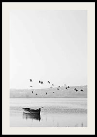 Black and white photo with flock of birds over a rowboat on lake-2