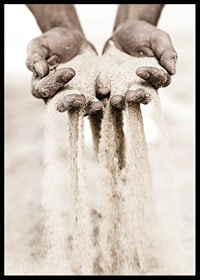 Photographie de mains libérant du sable dans des tons beiges doux-6