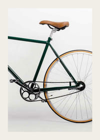 Photograph of green bicycle with brown saddle against light background-3