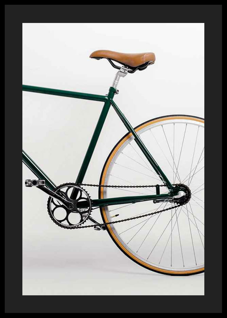 Photograph of green bicycle with brown saddle against light background-12