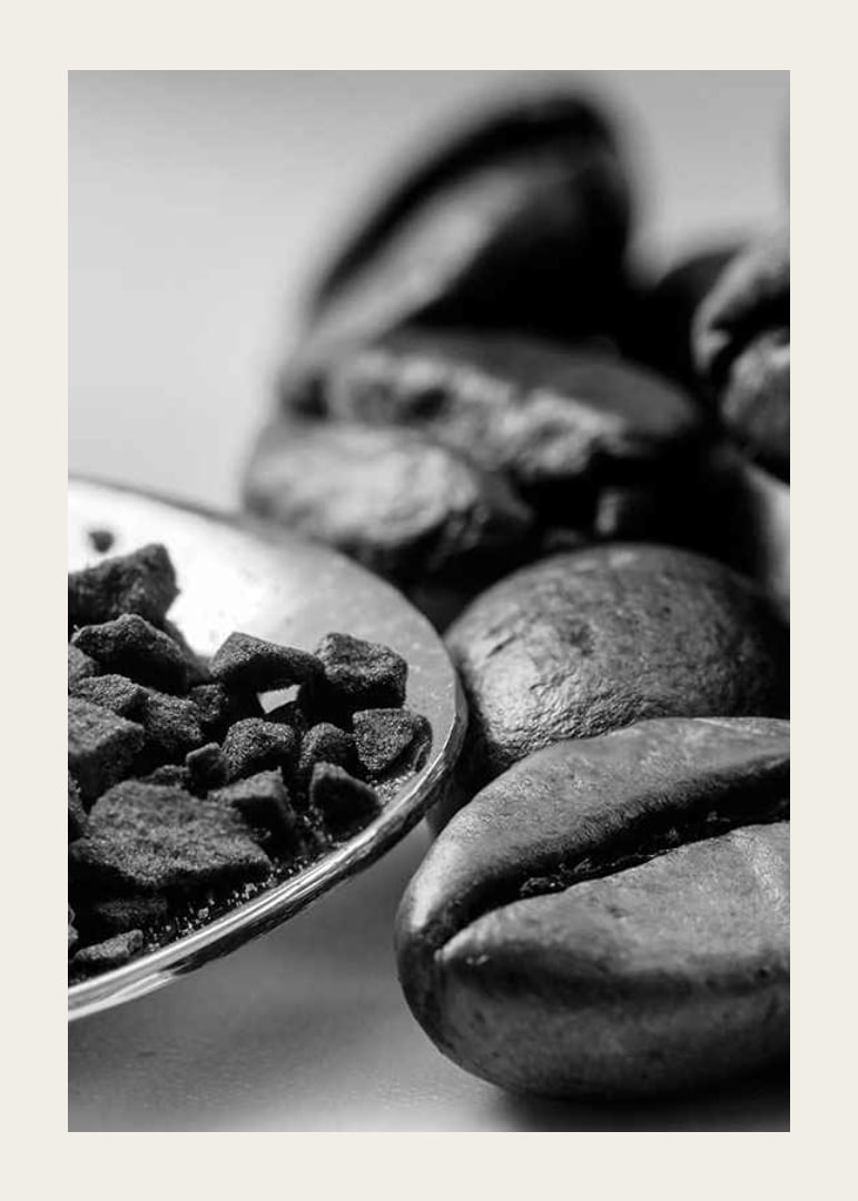 Black and white close-up of coffee beans and coffee powder on spoon-12