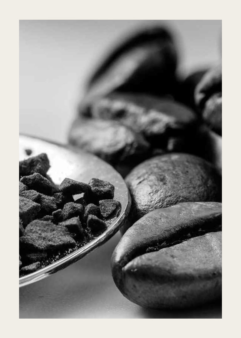Svartvit närbild av kaffebönor och kaffepulver på sked-12