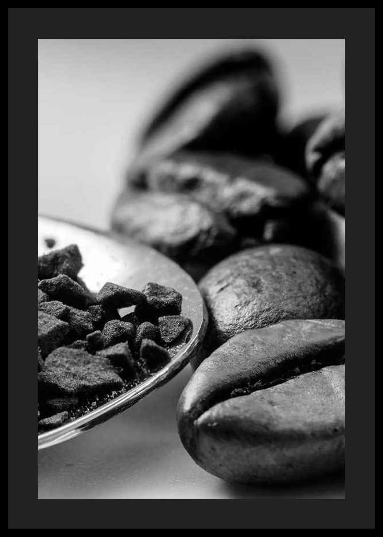 Svartvit närbild av kaffebönor och kaffepulver på sked-12