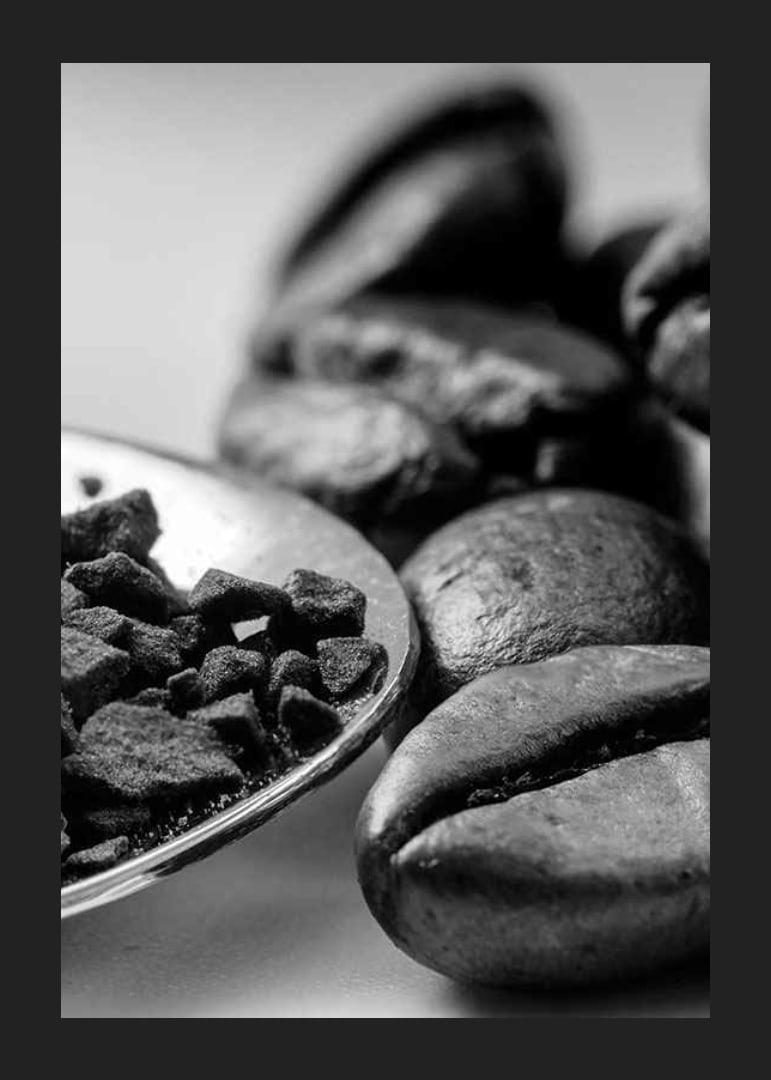 Black and white close-up of coffee beans and coffee powder on spoon-12