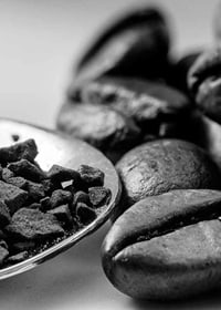 Black and white close-up of coffee beans and coffee powder on spoon-7